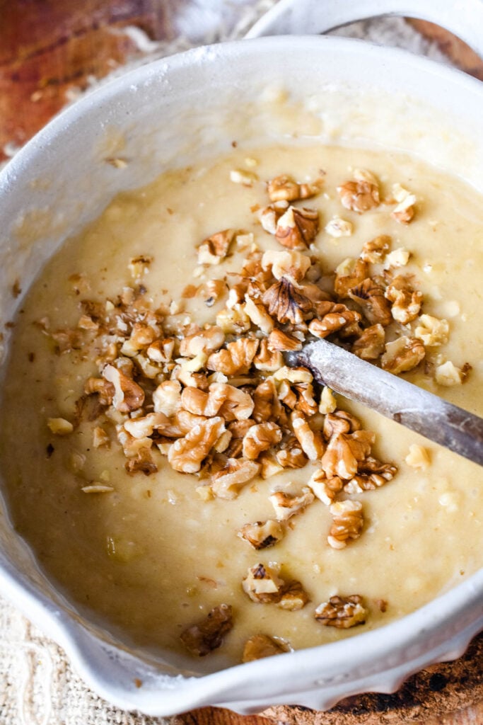 adding walnuts to banana bread cake batter