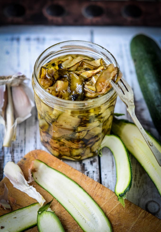 pickling fork in jar with grilled courgettes in oil