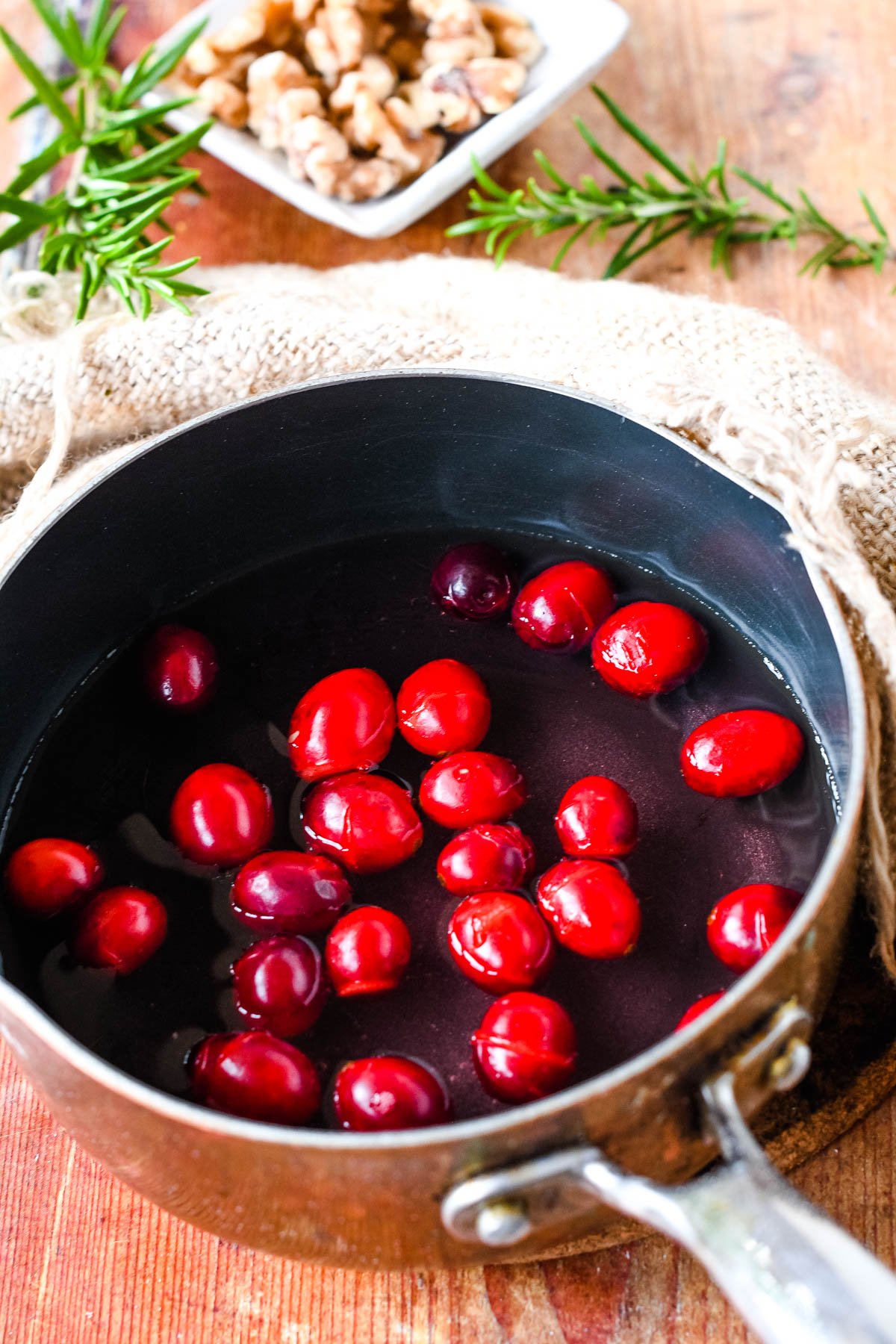 heating the cranberries in a small pan with water and sugar