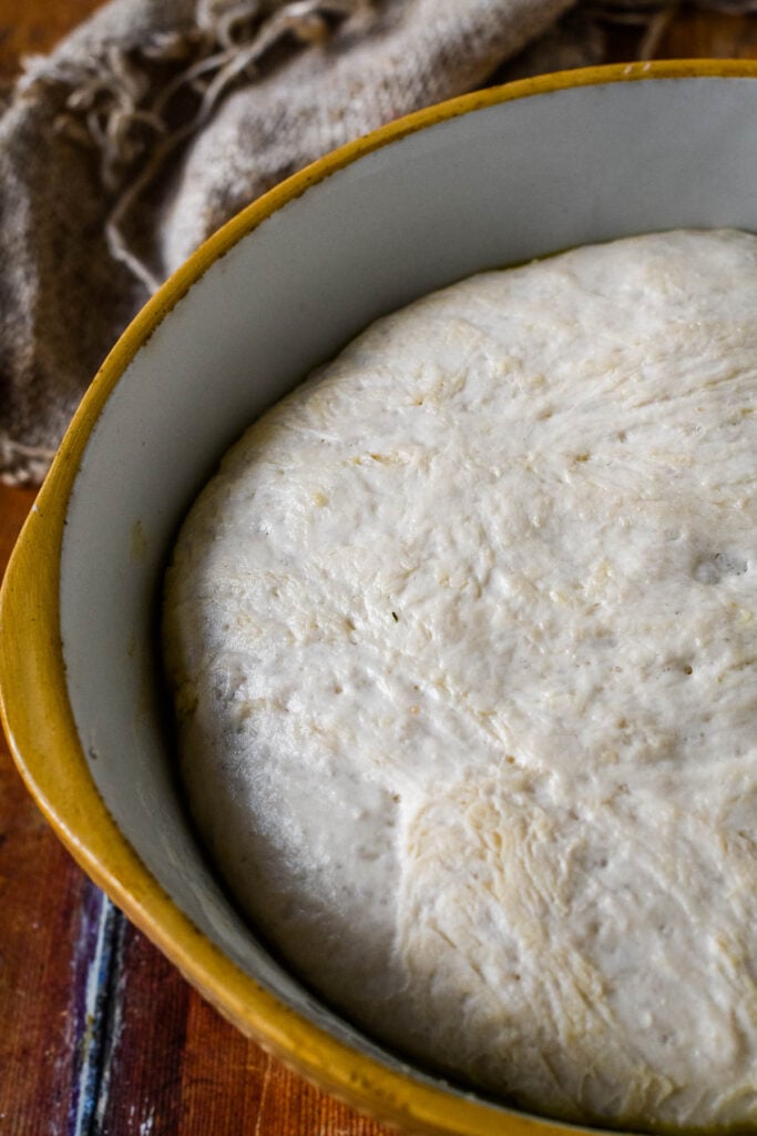 risen focaccia in mixing bowl