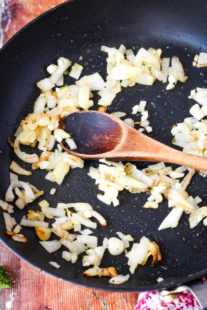 sauteing onion and garlic in frying pan to make tomato sauce