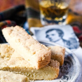 shortbread fingers on plate with glass of whisky behind