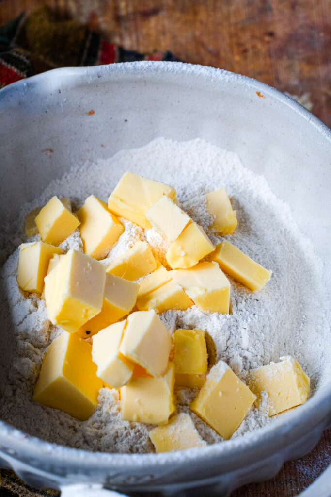 cubes of butter in mixing bowl with the dry ingredients