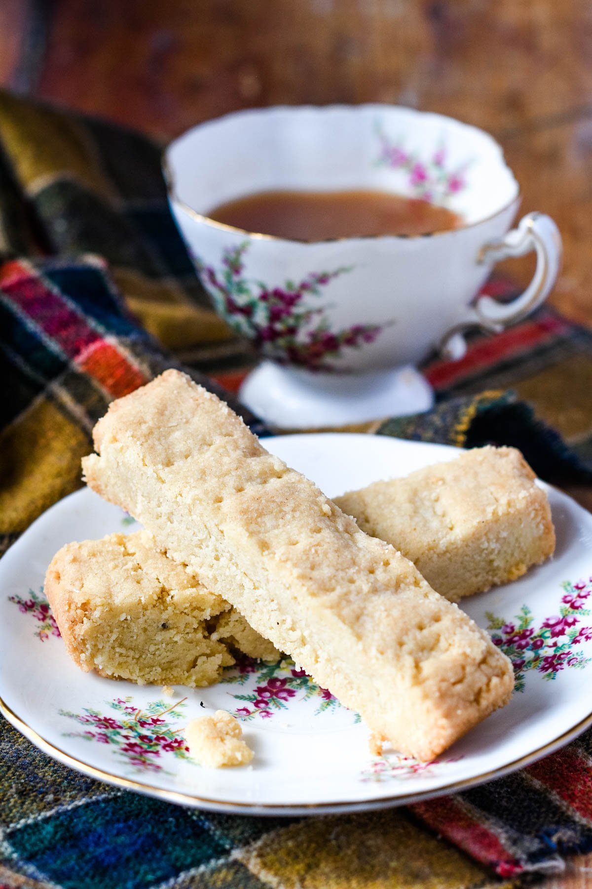 shortbread fingers on plate with cup of tea behind