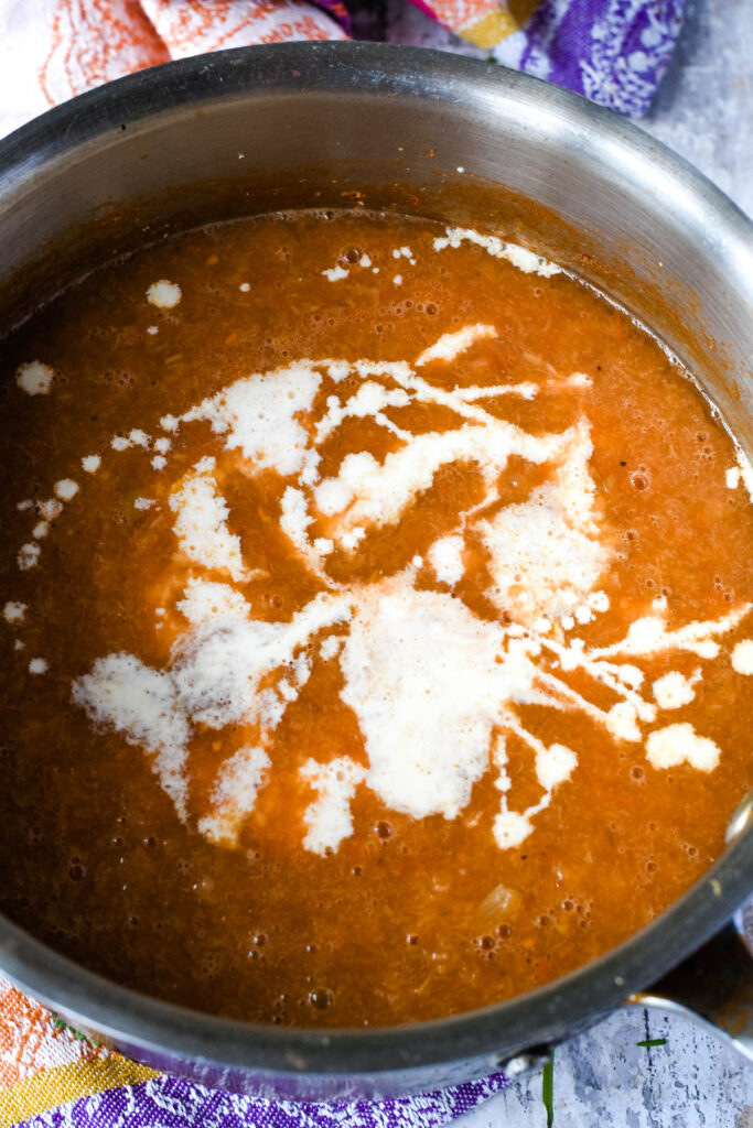adding cream to the blended soup