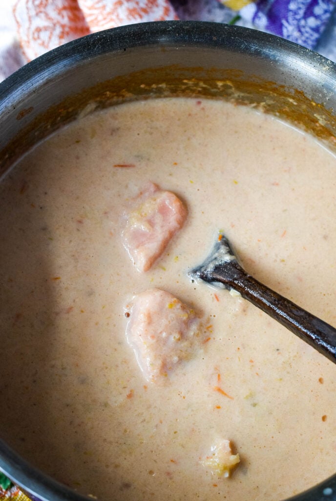adding the salmon to the soup pot