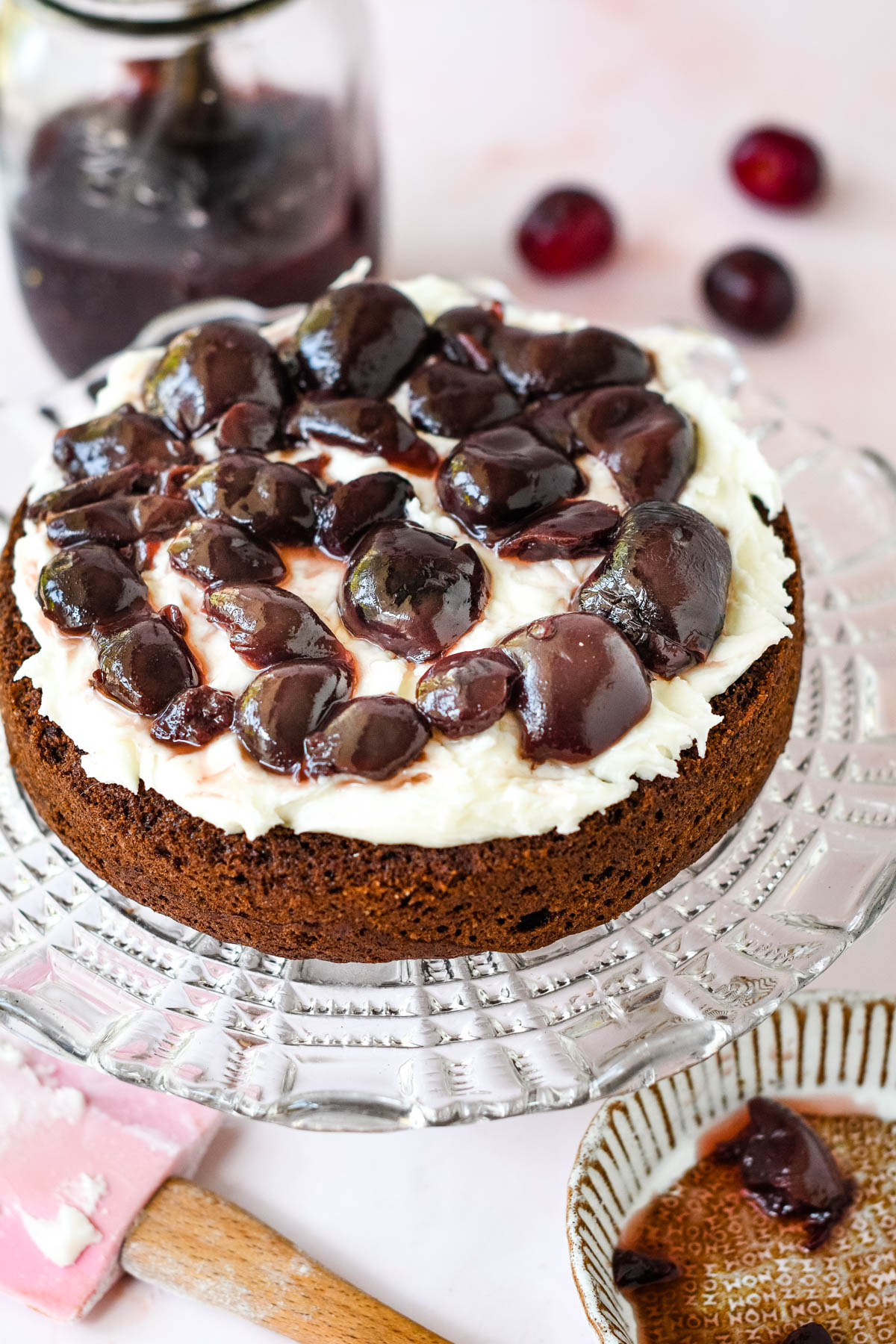 cake base with frosting filling and wine soaked cherries on top