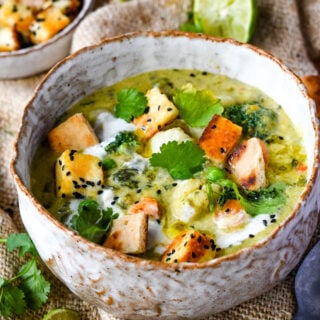 Curried vegetable soup in bowl with lime and croutons