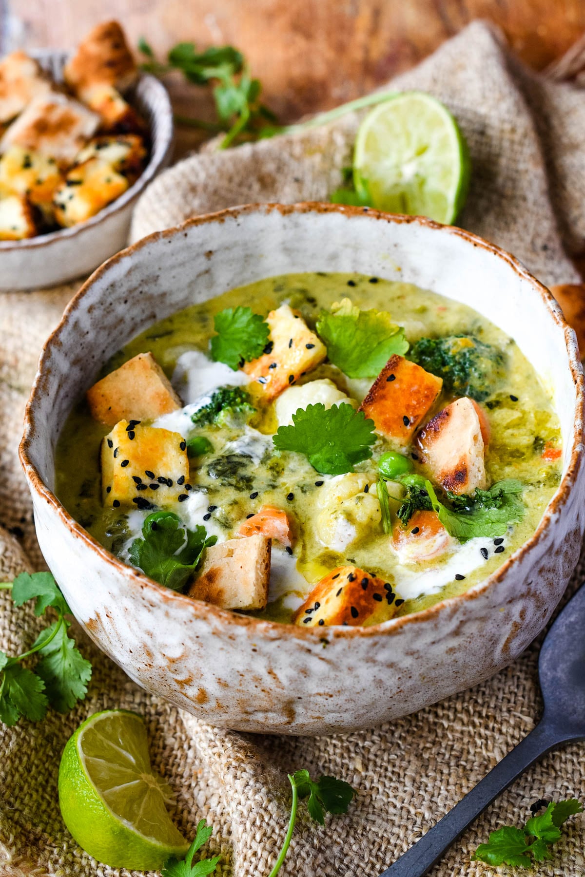 Curried vegetable soup in bowl with lime and croutons