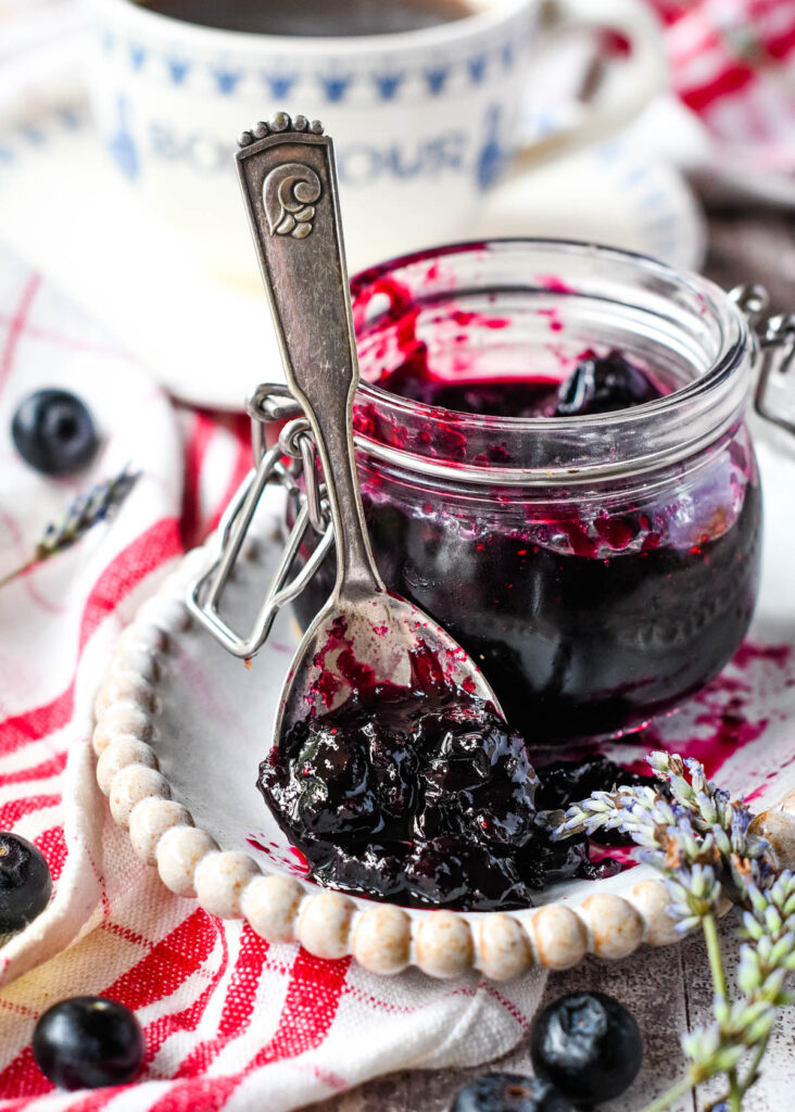 blueberry jam in jar with spoon at side