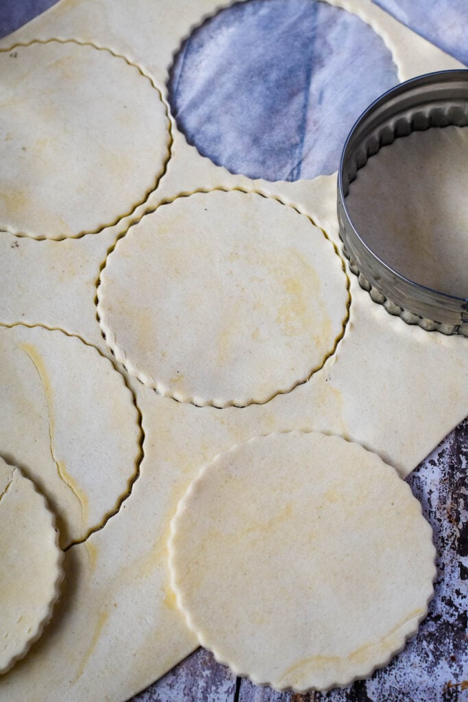 cutting out circles of pastry using cookie cutter