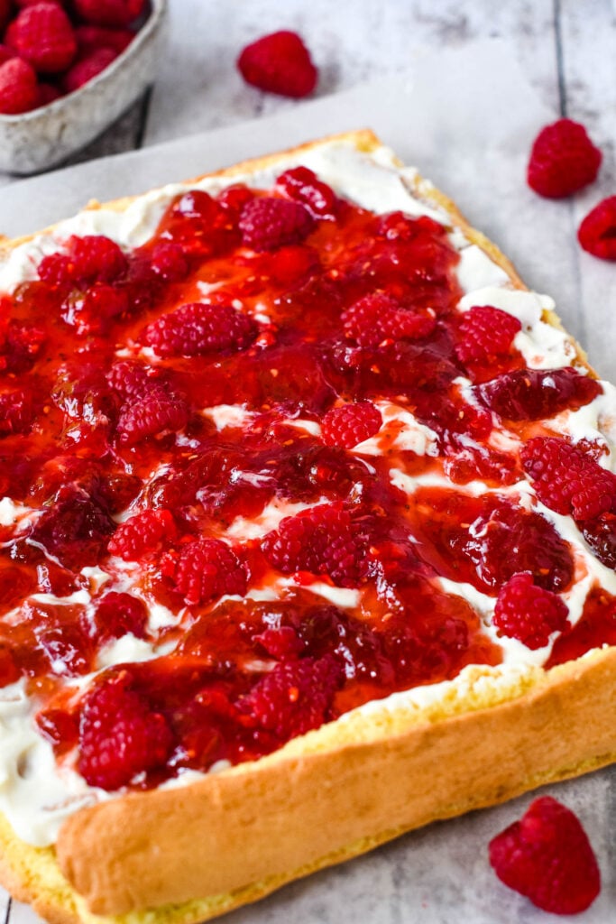 spreading the jam and frosting on cake base