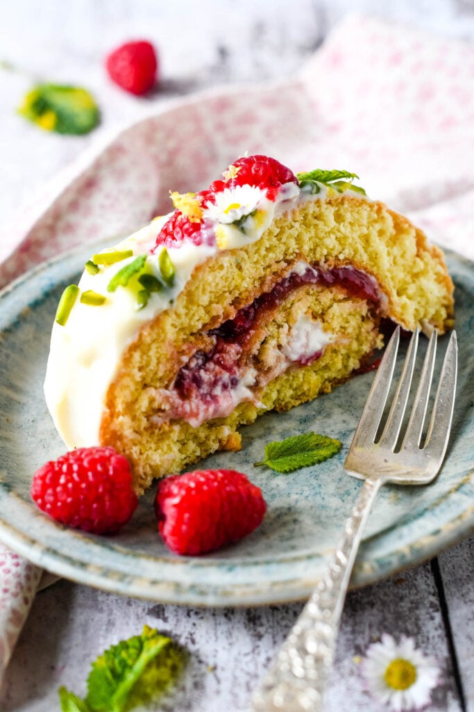 single slice of cake with raspberries on the side