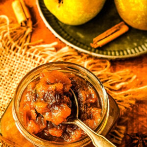 chutney with spoon in jar and pears behind