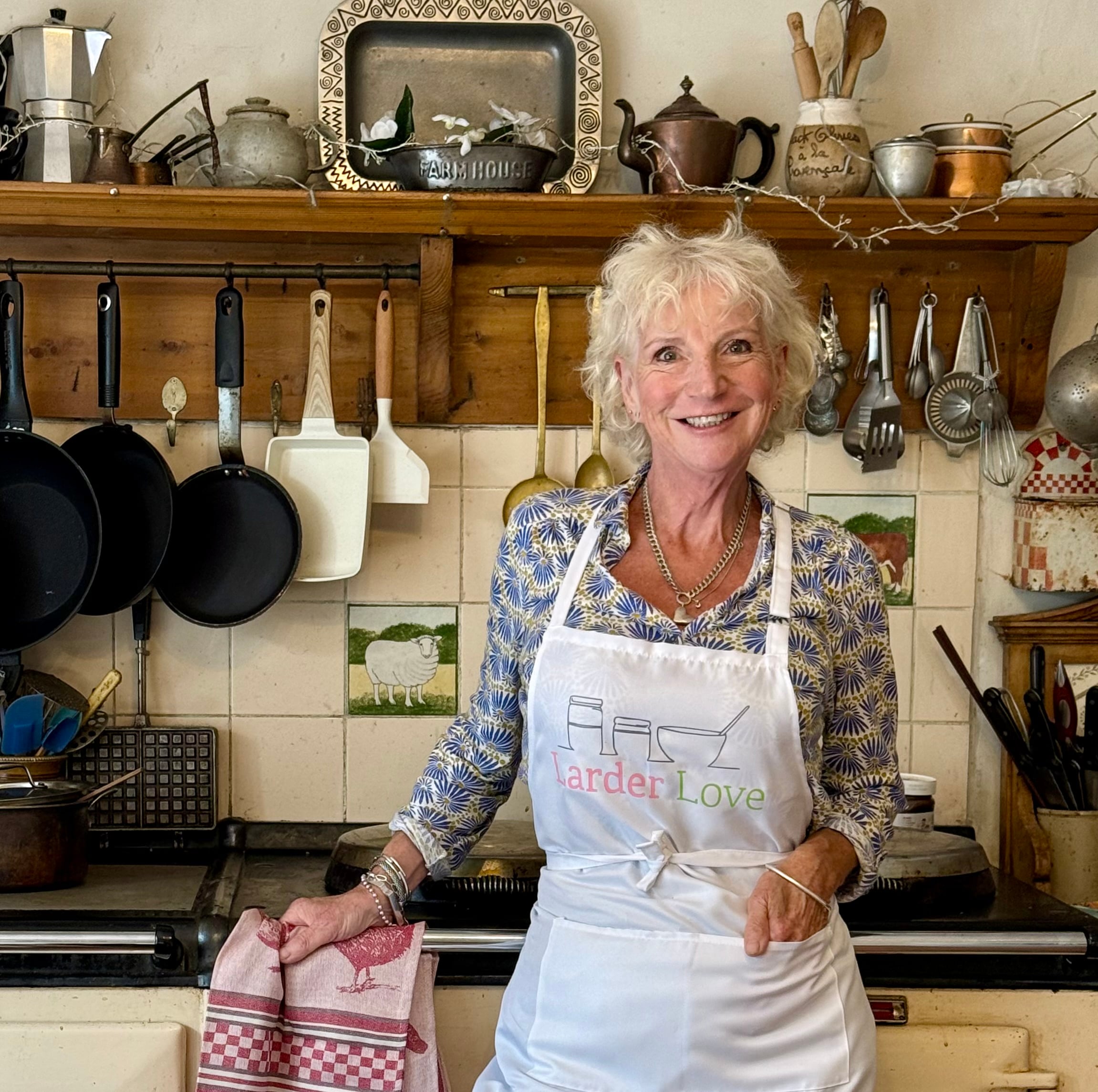 Karon Gieve in her kitchen leaning on her counter with all her utensils behind her.