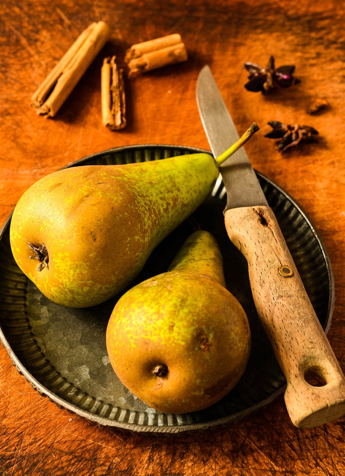 Pears on a plate with knife and spices